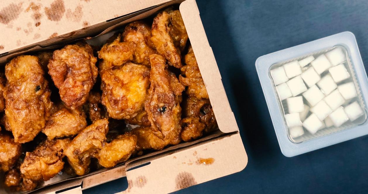 Hộp gà rán hương vị mật ong từ Kyochon và một phần củ cải muối để kèm theo.