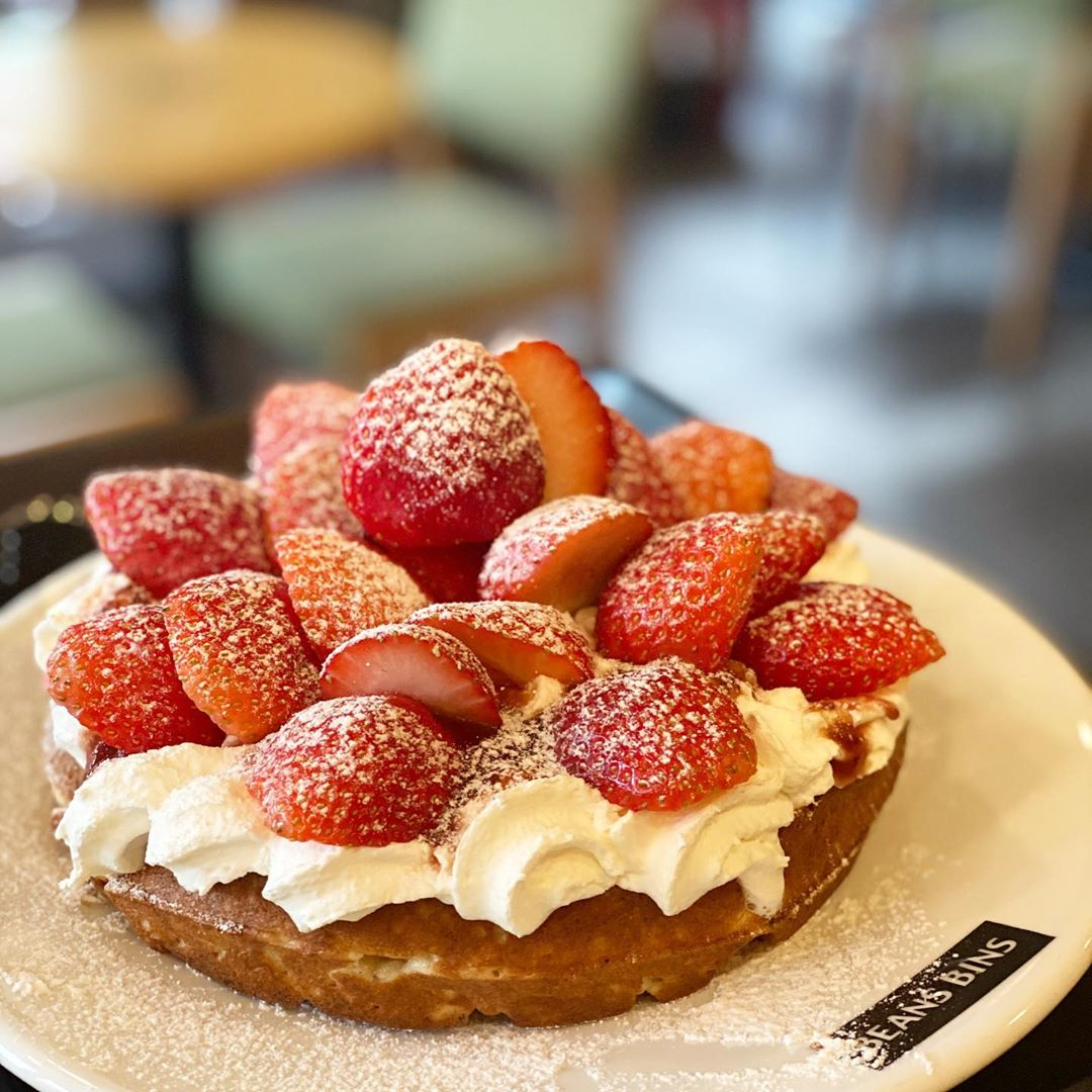 Beans Bins咖啡厅草莓松饼，撒上糖霜的鲜红草莓覆盖在松软饼上。