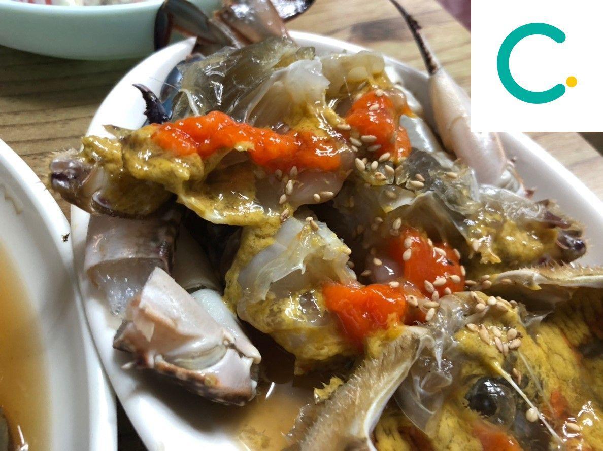 韓國傳統料理醬油螃蟹，螃蟹以醬油浸泡，鮮紅色的膏體與芝麻點綴在上。」