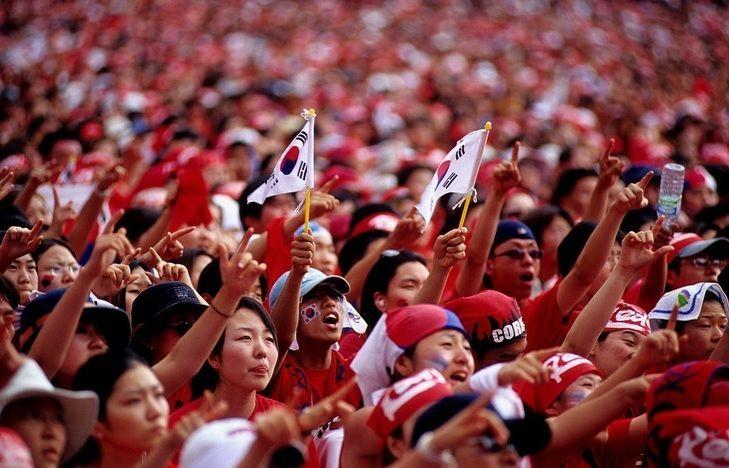 在大型公开场合和街道上，支持者穿着红色服装公共观看直播的热情景象.