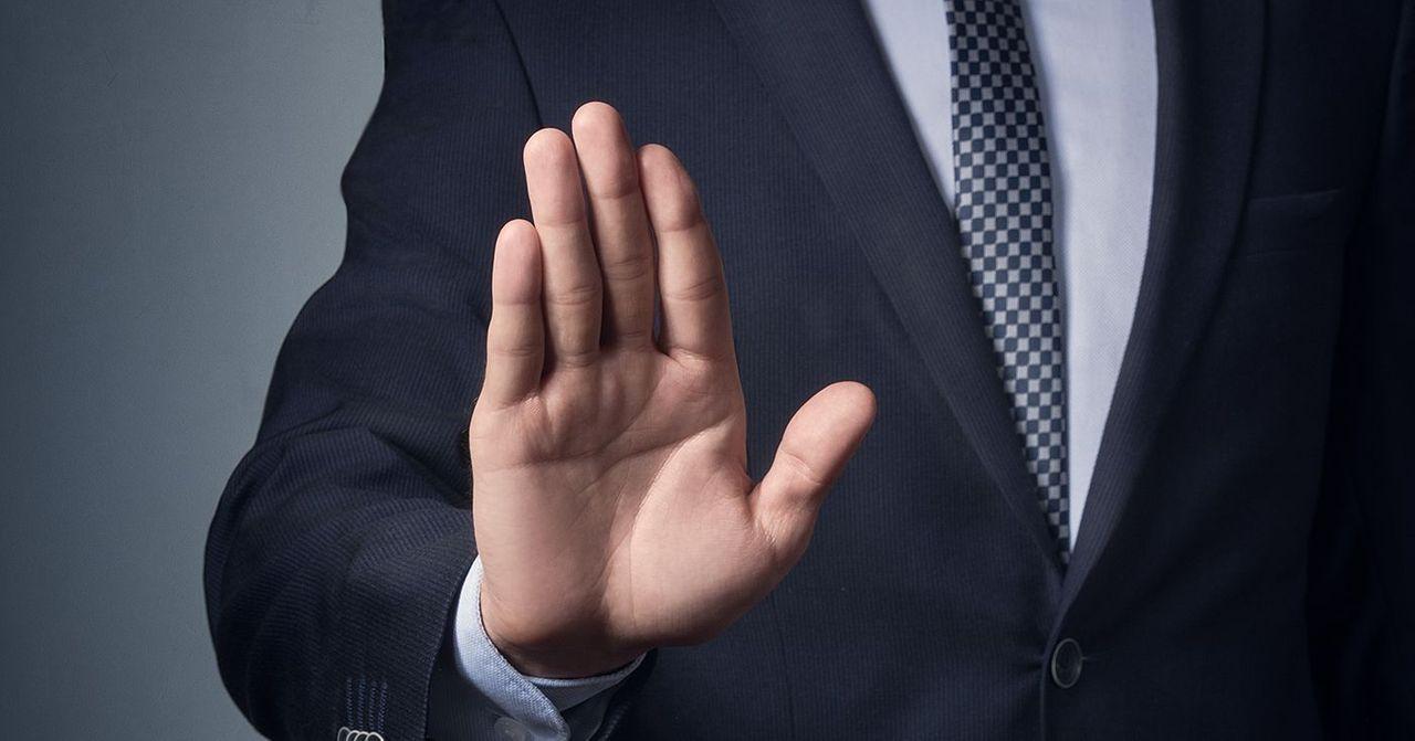 한국에서 조심해야 할 금지 사항을 나타내는 손바닥으로 멈춤을 의미하는 비즈니스맨의 손 이미지.