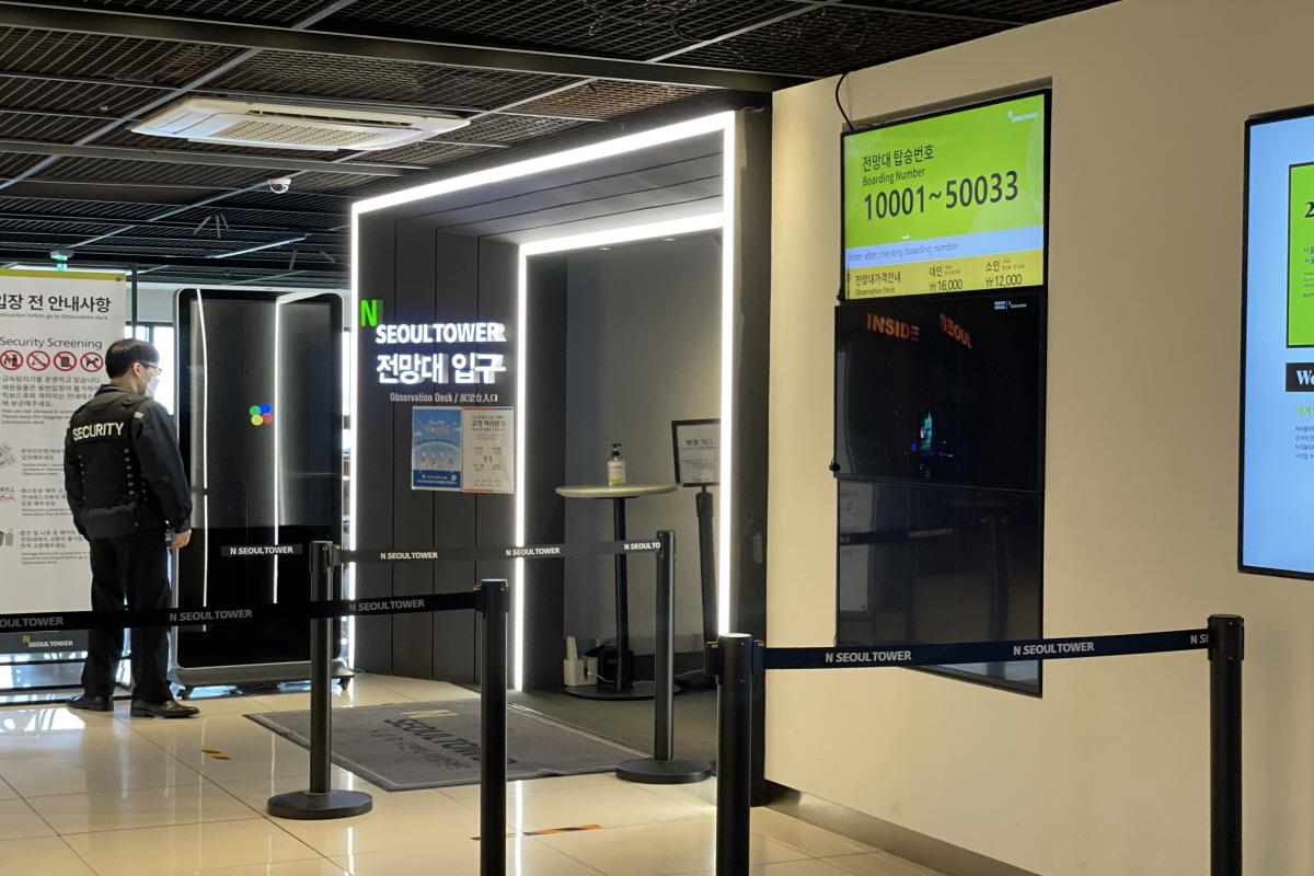 N首爾塔自助售票機顯示首爾標志性景觀的購票過程，提供即時票務服務，提升遊客進場效率，分享首爾城市景色。