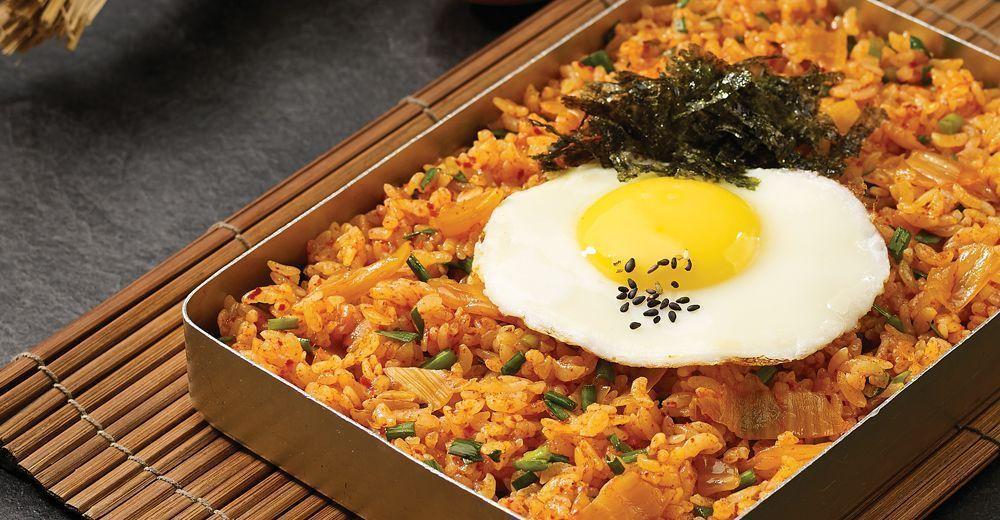 方形盒裝的泡菜炒飯，上面鋪著金黃的煎蛋，配上紫菜與芝麻，讓這道韓國家常料理變得更具引人注目的魅力。
