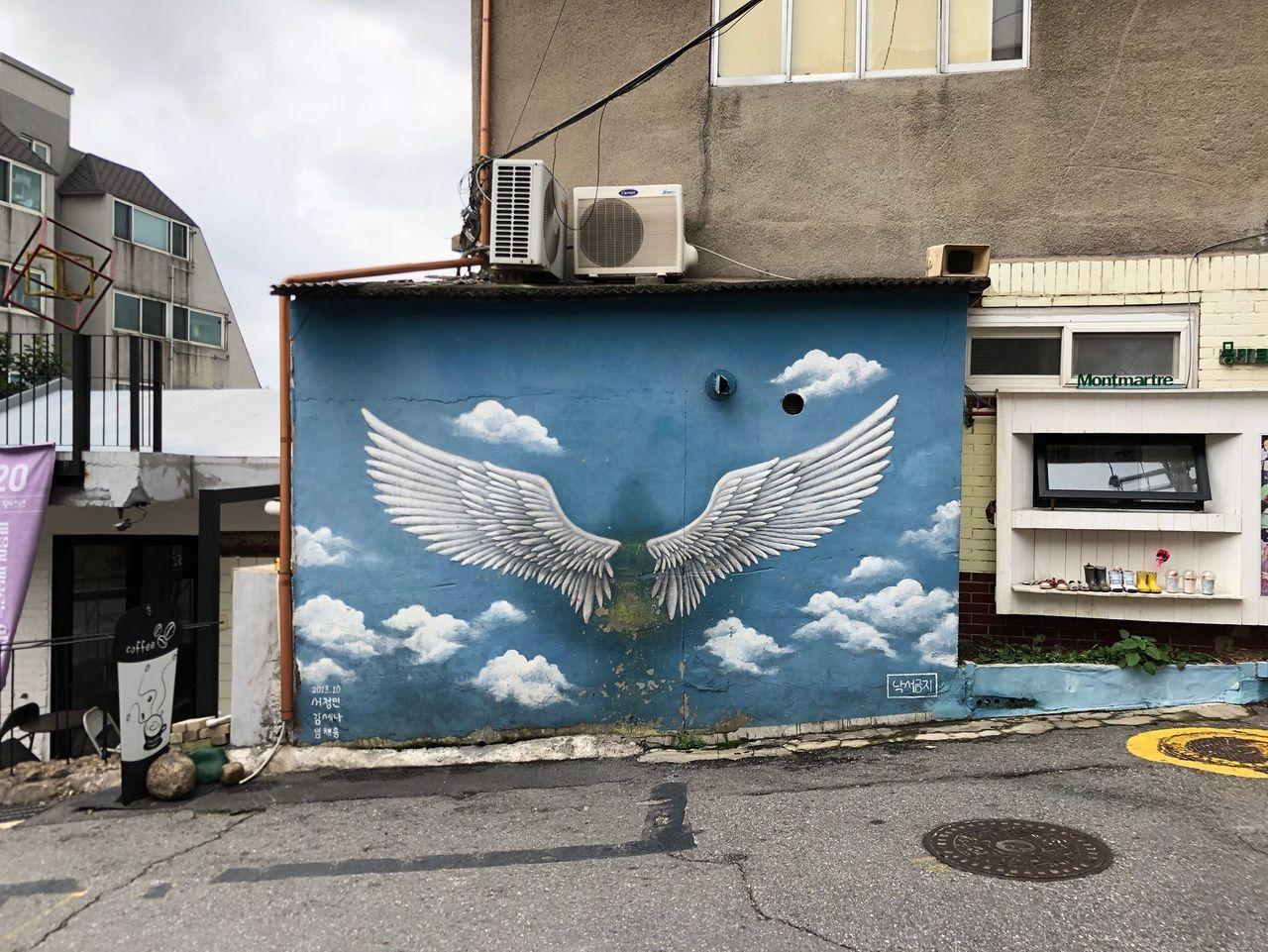 梨花洞壁画村中的一幅蓝色背景的翅膀壁画。