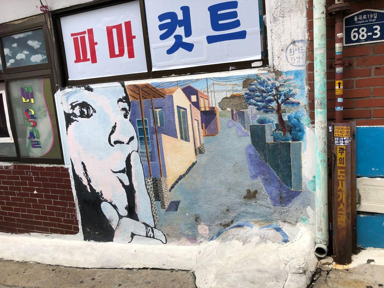 梨花洞壁画村中的现代风格壁画和老建筑对比。