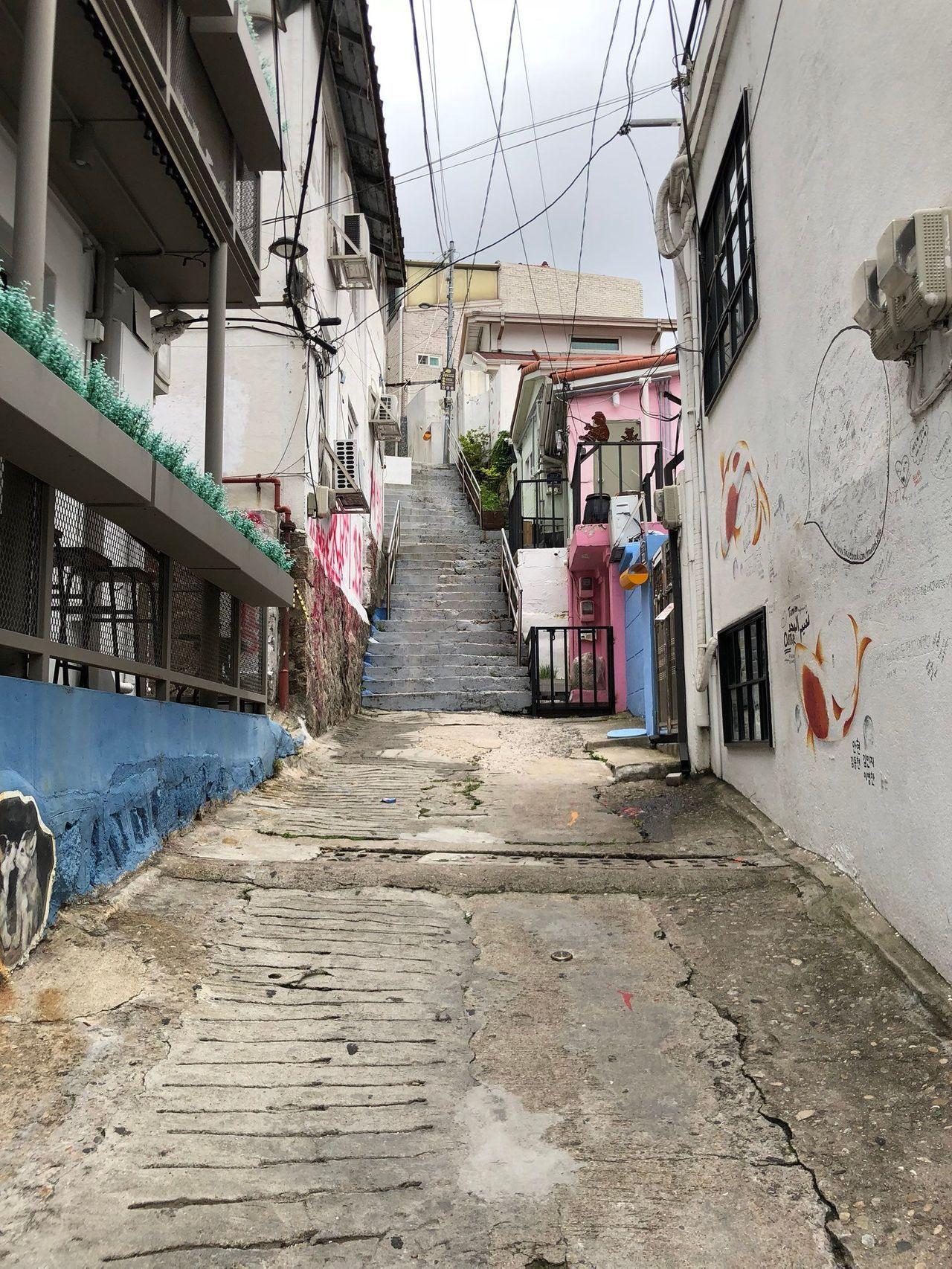 梨花洞壁画村的街道图，显示墙上不同风格的壁画。