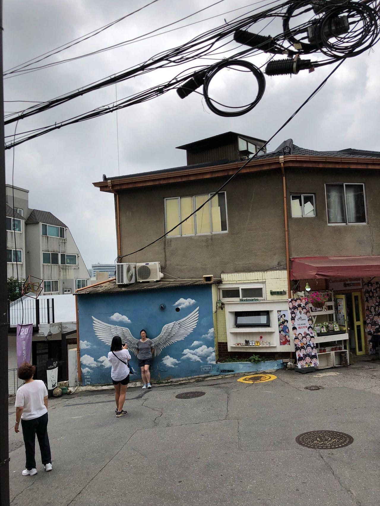 梨花壁画村中的红色字迹，居民希望恢复宁静生活的表达。