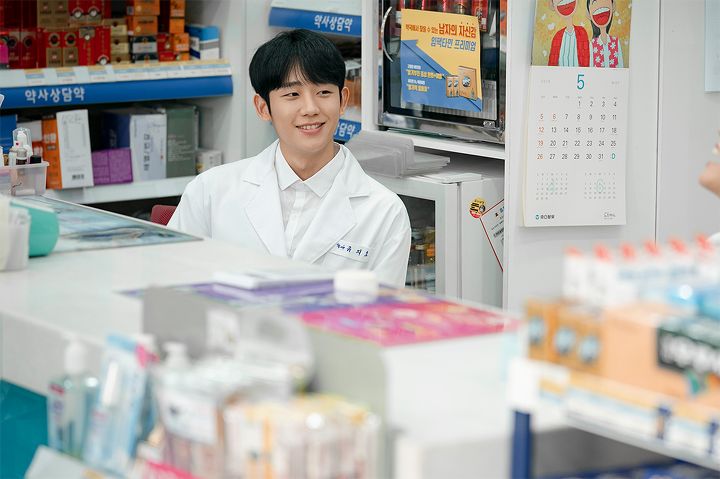Interior of a Korean pharmacy featuring shelves with medication and informative health posters, highlighting the role of pharmacists in the healthcare sector.