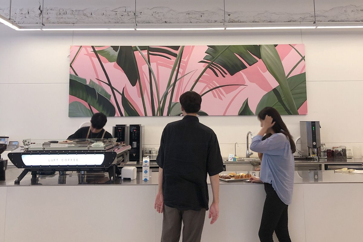 咖啡廳內的自動咖啡機和牆上的裝飾畫，營造舒適的氛圍。