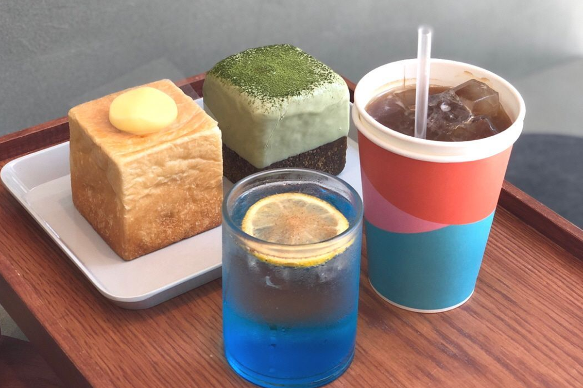 精緻擺盤的甜點，如迷你蛋糕和色彩鮮艷的飲品在木託盤上展示。