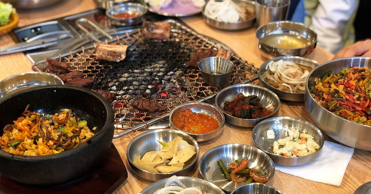 韩国传统餐桌设有丰富的菜肴和调料，呈现出本土饮食文化的丰富多彩.