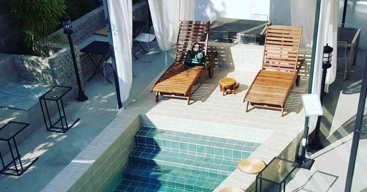 首爾的必去咖啡廳，圖中展示了一家露天咖啡廳的戶外休憩區，有躺椅和淺水池，營造悠閒的氛圍。