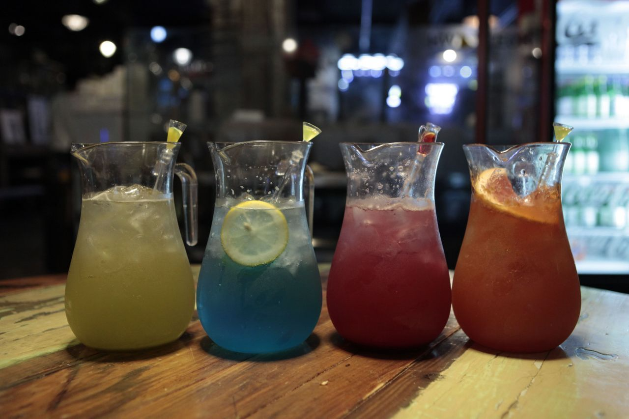 Four colorful pitchers of 1L Ade at Hwa Tteok, with flavors like grapefruit, blueberry, grape, and strawberry, ideal for sharing among two people.