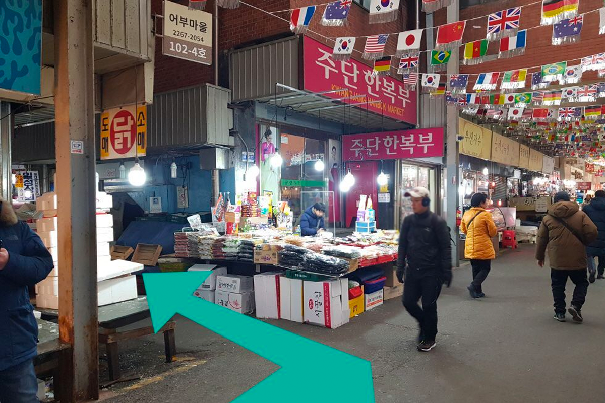 市場走道的交錯口，沿著箭頭方向轉角，這裡充滿了不同國家的小旗子裝飾。