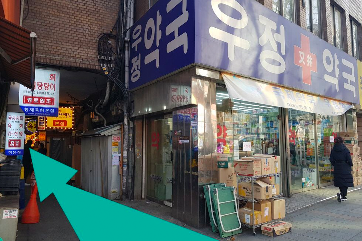 經過藥房進入小巷的方向指引，這裡兩側皆有商家，雜貨攤和店鋪主要是日用商品。