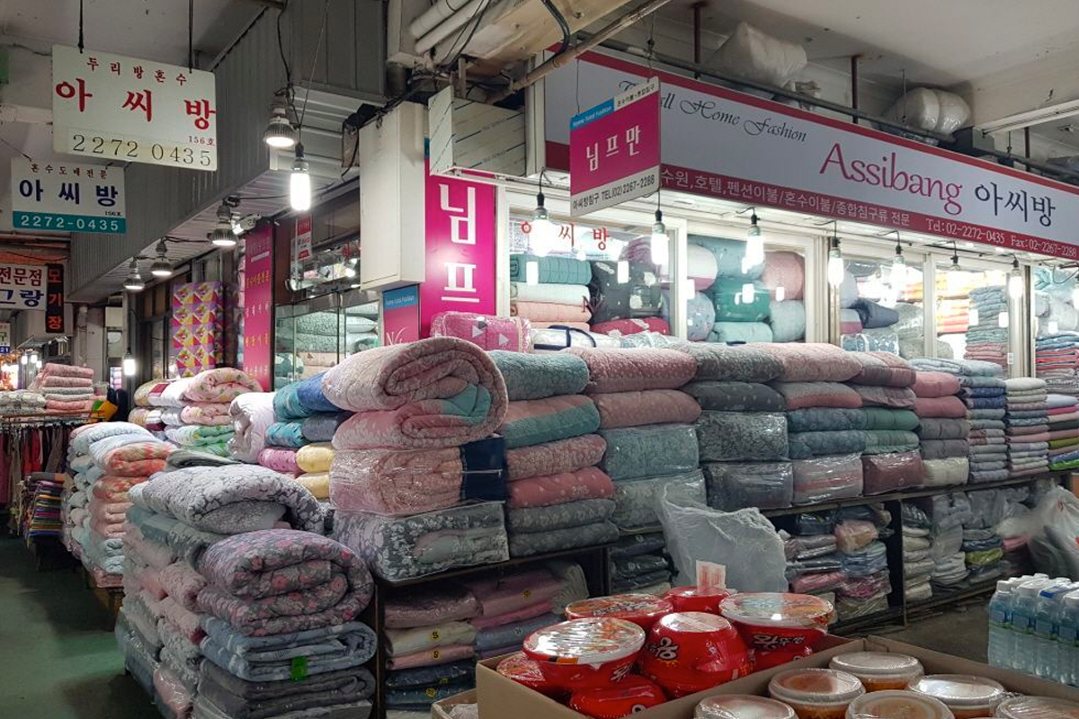 市場的終點影像，這一區域主要陳列了許多棉被等家庭紡織品，為旅客提供温暖的選擇。