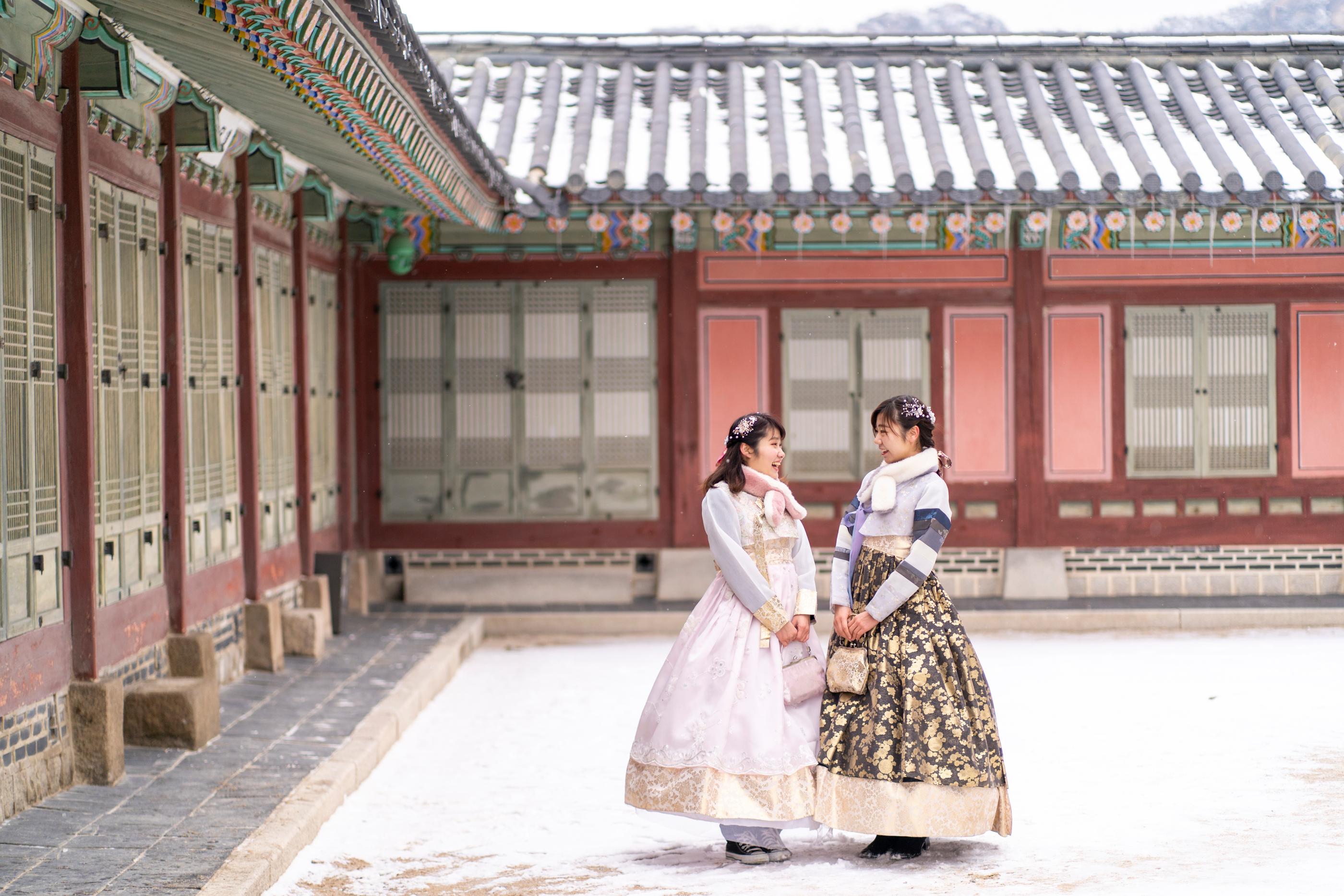 スペシャル韓服を着た二人が宮殿の前で立っている様子