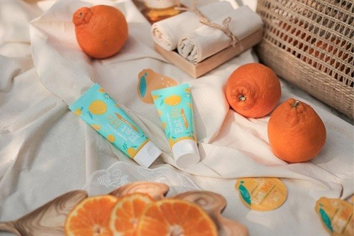 Jeju orange-flavored toothpaste surrounded by Jeju oranges.