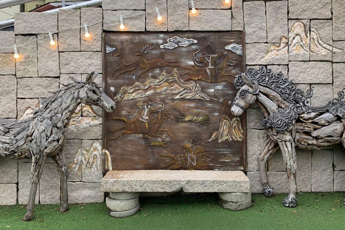 甘川文化村的藝術角落，有馬形雕塑和以山川為背景的浮雕，展現獨特的藝術氛圍。