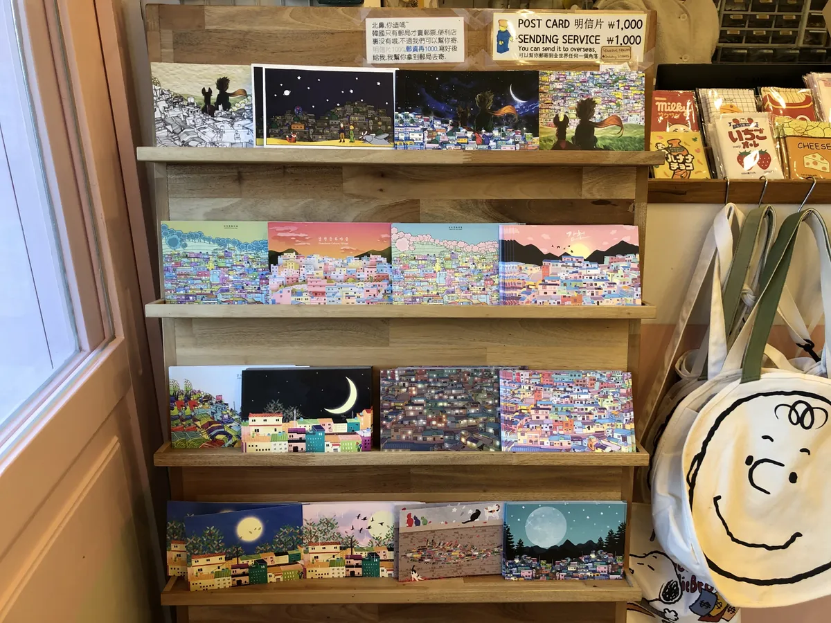 甘川村明信片和手袋展示，五彩繽紛的設計展現出其獨特的文化藝術創意。