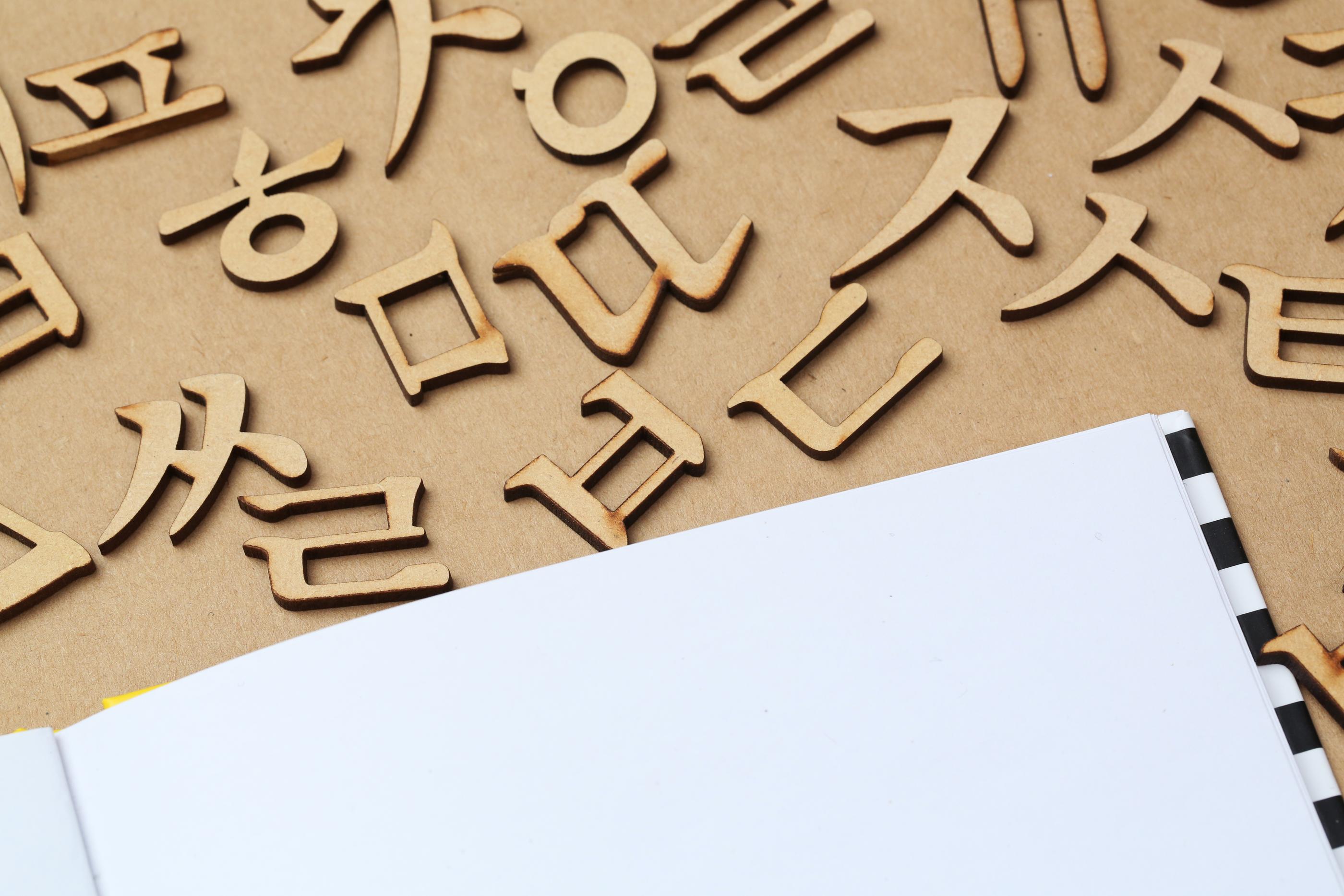 Wooden letters of the Korean alphabet, Hangul, spread across a tabletop.