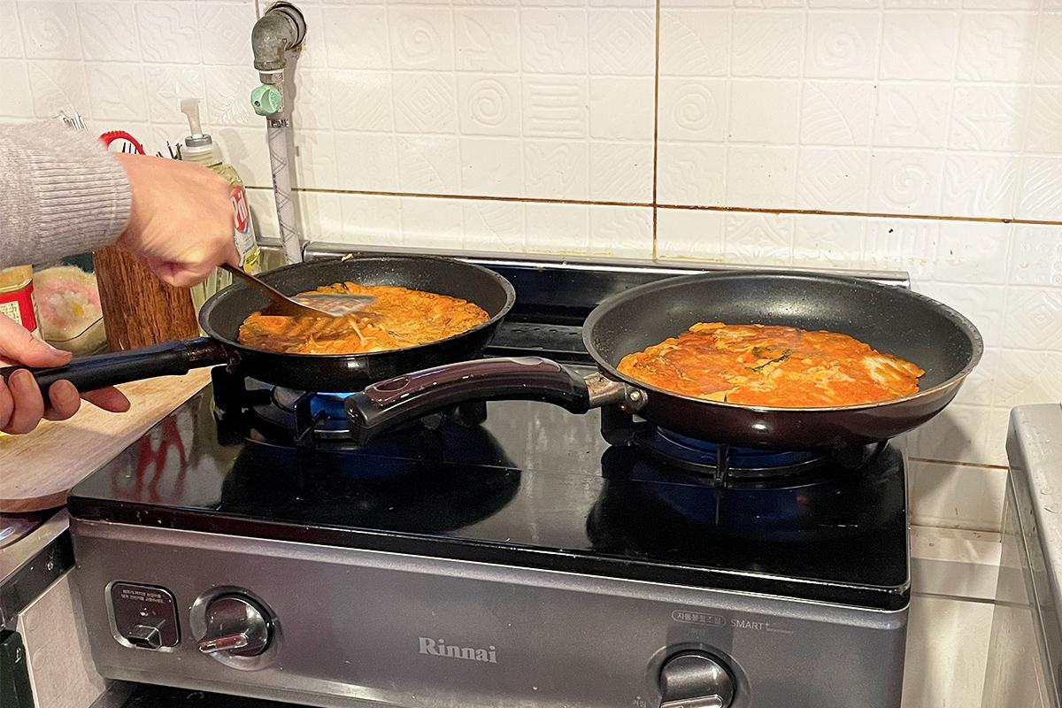 Dip a piece of kimchi pancake into soy sauce as a tasting experience.