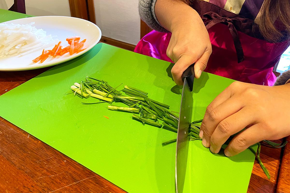 Participants julienne vegetables as a step in making kimchi during the class.