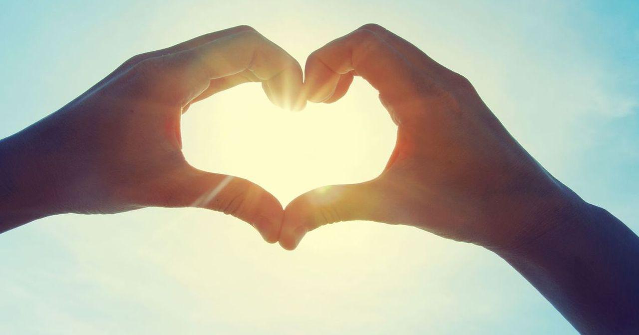 心形手勢圖案，背景是藍天，象徵著愛情的美好與浪漫，讓人心情愉悅的美好時刻。