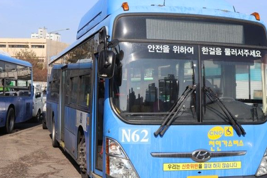 首爾N62夜間公車停在站內，車身印有標識和號碼，為夜間旅客提供從弘大到其他地區的交通便利。