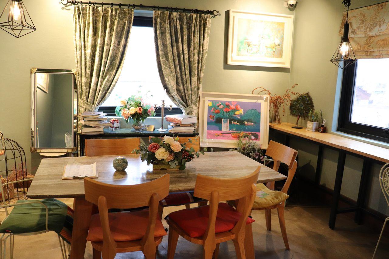 Ein Esstisch in Maison Cote, dekoriert mit Blumen und Gemälden.