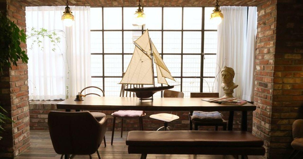 室内复古风格餐饮空间，木制桌椅和模型船装饰，营造出温馨的用餐环境。