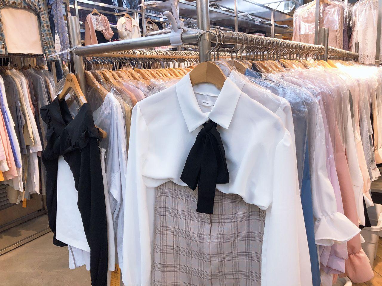 色彩丰富的吊挂服装，展示在釜山西面的服装店里，吸引顾客驻足。