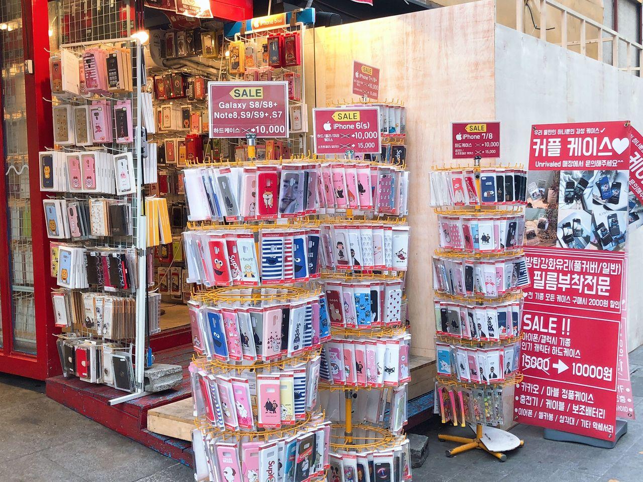 釜山西面购物商圈内手机壳商店的展示墙，展示各式新潮设计。