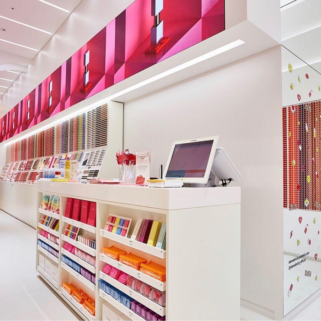 石頭磚店內陳列整齊，展示多彩化妝品，具有樂高設計風格。