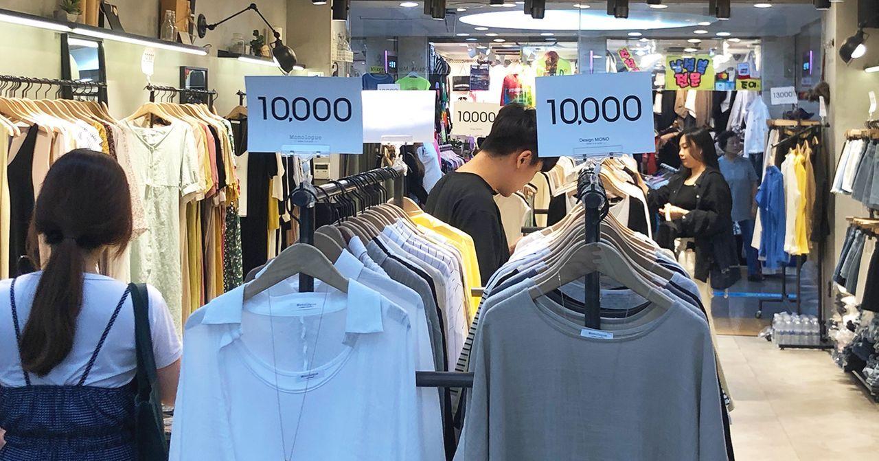 首爾流行服裝店，店內掛有各類風格服裝，標示吸引的售價。
