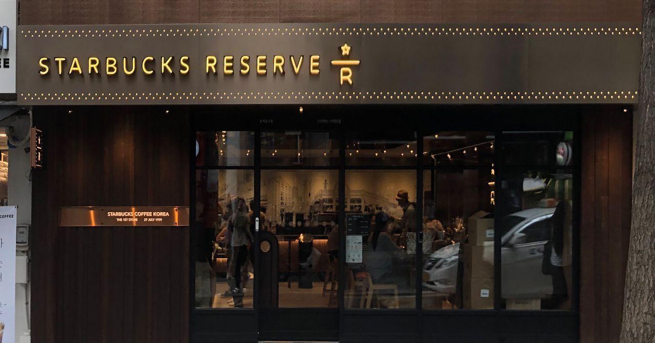 首爾梨大星巴克門面，招牌以暗黃色字體呈現，環境舒適設計。