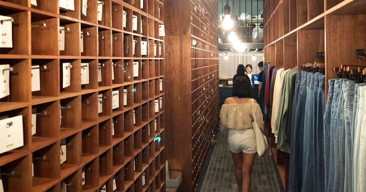 裝修風格特殊的服裝店，木製貨架上陳列各類牛仔單品，展現獨特購物體驗。