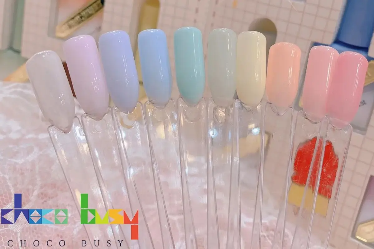 釜山美甲店展示多種柔和色調的指甲樣本，包括粉色、藍色和綠色等，適合不同風格的美甲設計。