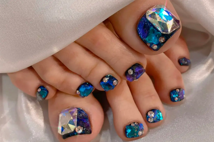 腳部美甲特寫，運用了閃耀的水鑚和鏡面效果的設計凸顯優雅與時尚感。
