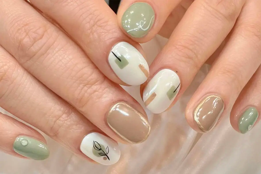 已完成的手部美甲近照，特寫展示以綠色和白色為主的幾何設計，美甲富有藝術感。