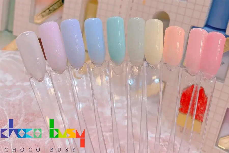 展示美甲樣板的色卡，展示柔和的彩色系美甲顏色，包括粉色、藍色等多種色調。