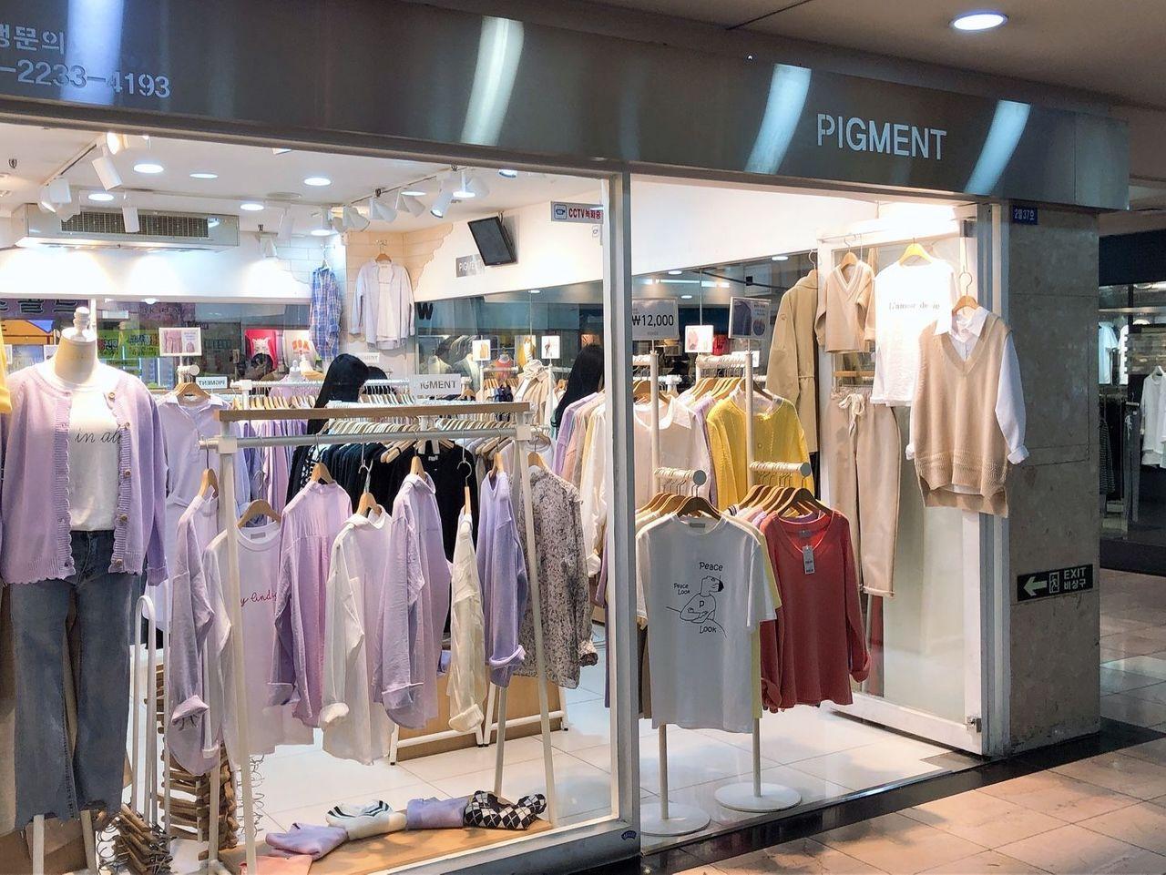 釜山地下街时尚服饰店橱窗，色彩缤纷的春季系列衣物一览无余。