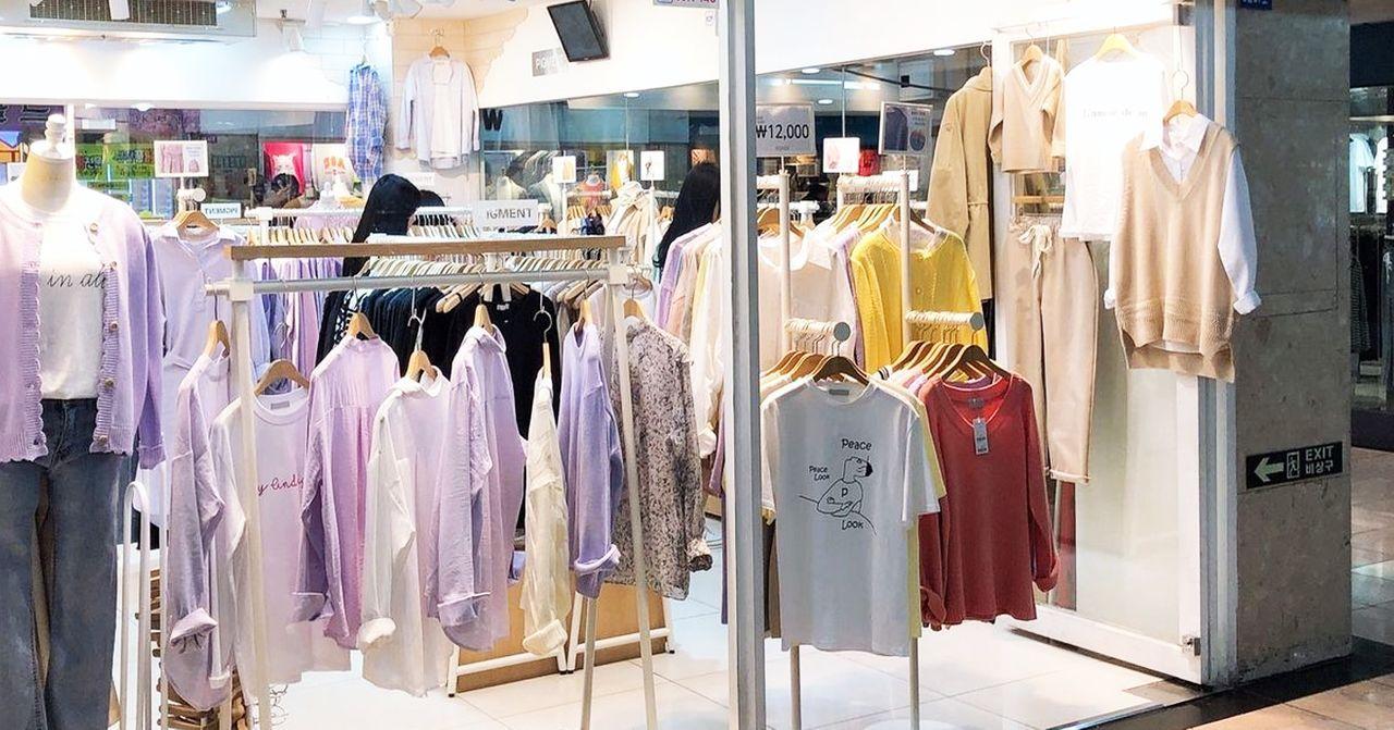 釜山时尚服饰店，挂满了最新款式的衣物，吸引顾客眼球。