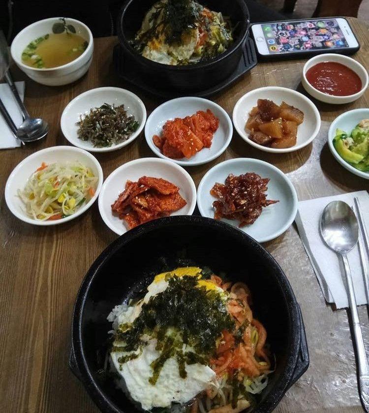 釜山传统韩式餐桌，摆满了丰富的小菜和主菜，色彩艳丽而诱人。