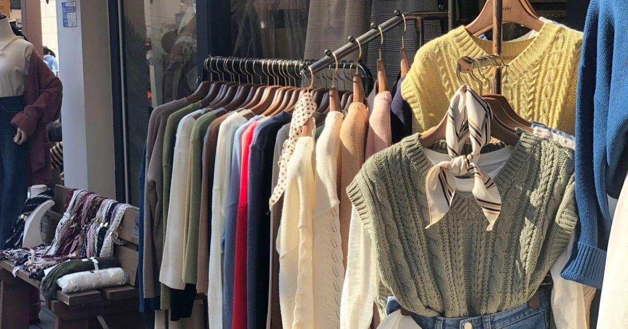 梨大商圈的街头服饰店，展示各式现代与休闲风格的时尚衣物。