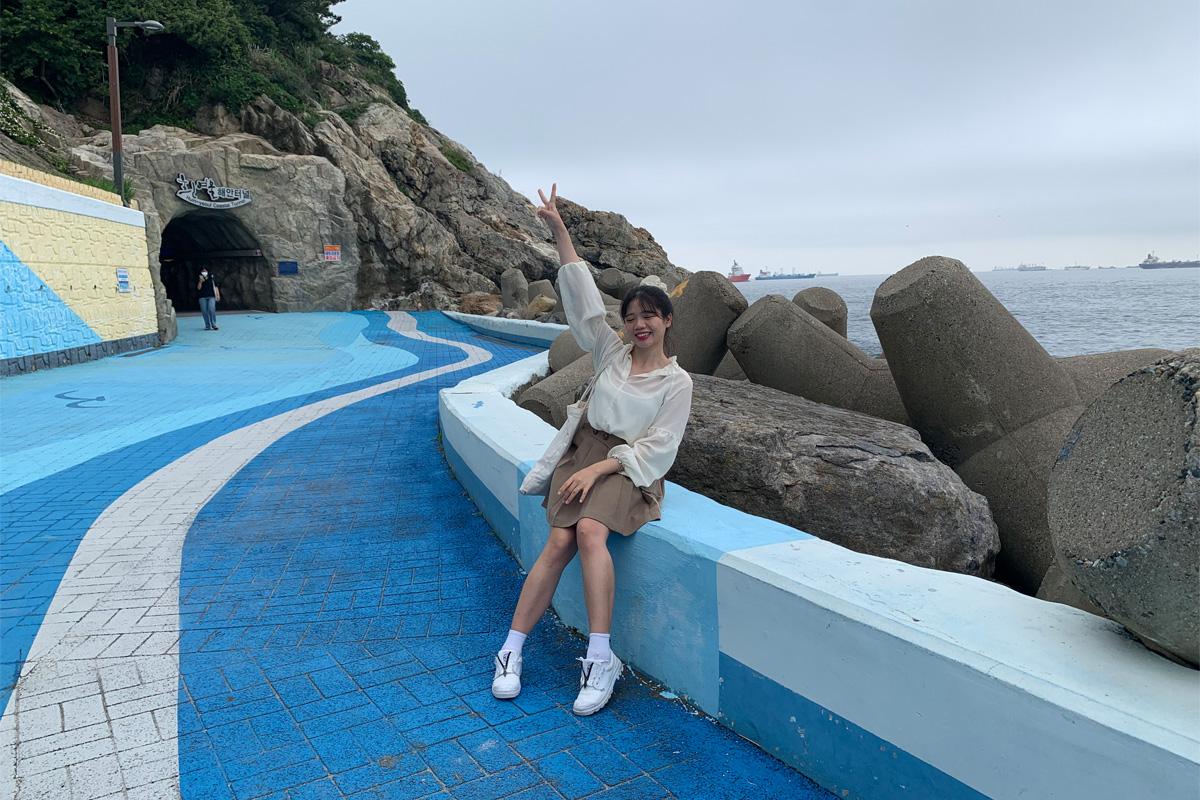 woman on the coastal promenade by the tunnel in Huinnyeoul Culture Village