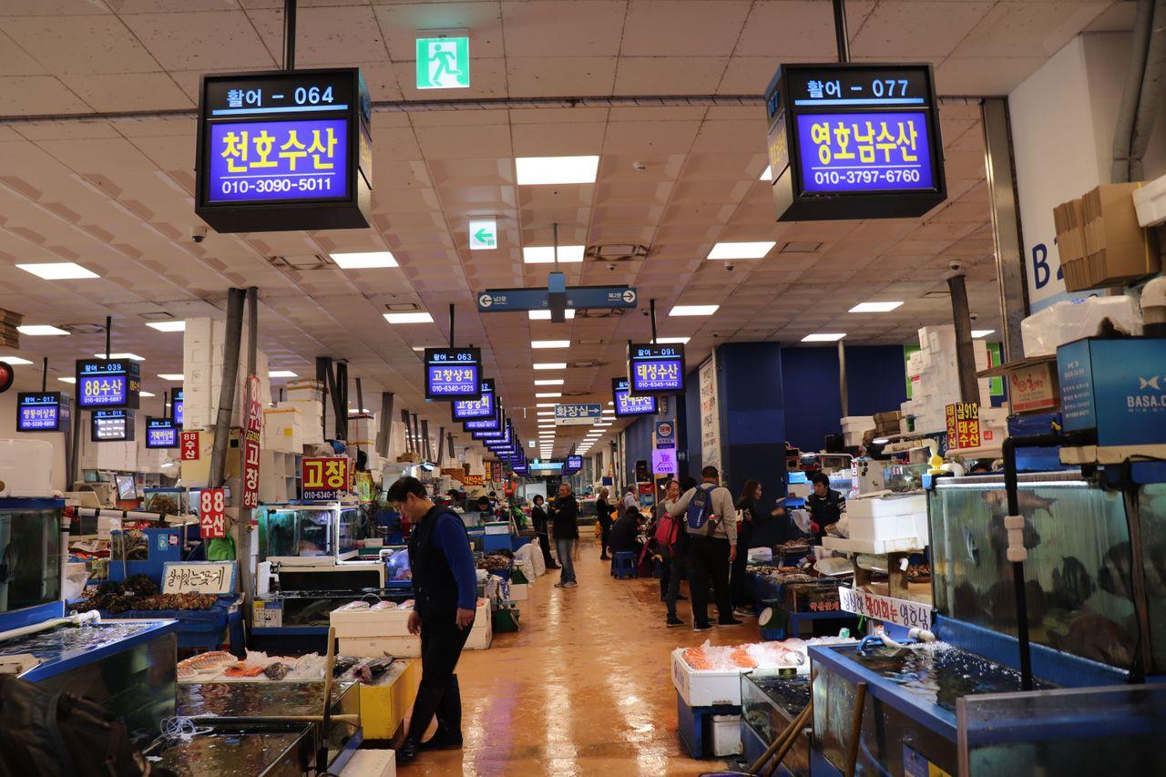 ノリャンジンフィッシュマーケット内の通路。新鮮な魚介類と様々な海産物を販売するショップが多数並ぶ風景。