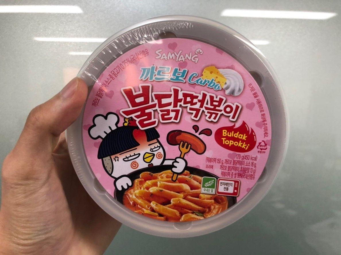 Samyang三养品牌Carbo火鸡辣炒年糕包装，浅粉红色设计吸引辣味食品爱好者。