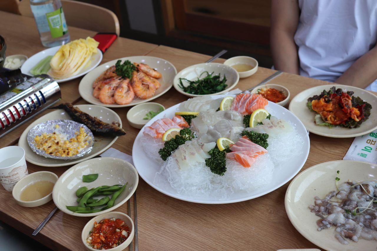 Surtido de sashimi con limón y adorno verde, presentado en el Mercado de Pescado de Noryangjin, Seúl.