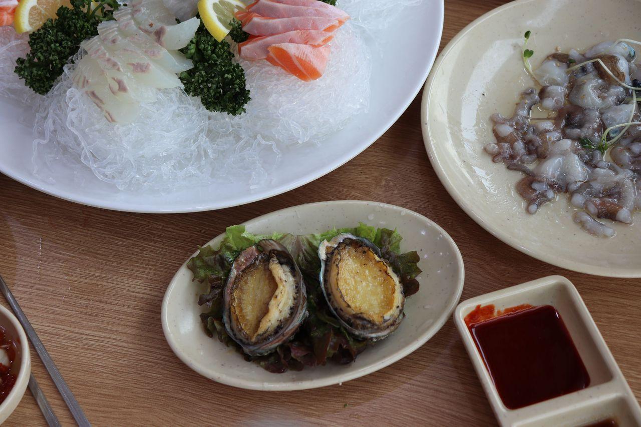 Abulones a la parrilla con mantequilla, servidos en el Mercado de Pescado de Noryangjin, Seúl.